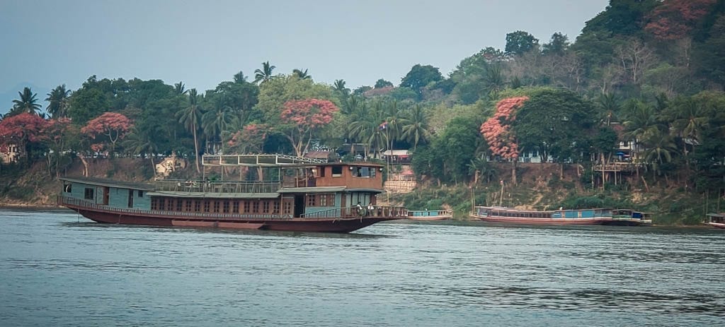 A boat on the Mekong River in Luang Prabang where you can release a fish and make a wish in Southeast Asia.