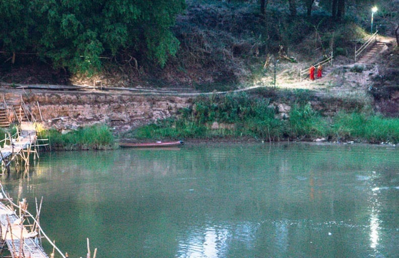 Monks on the Mekong River in Luang Prabang where you can make a wish in Southeast Asia.