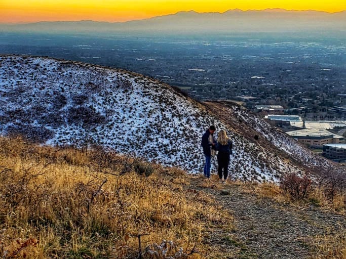 A couple taking pictures on the Living Room Lookout Trail in Utah