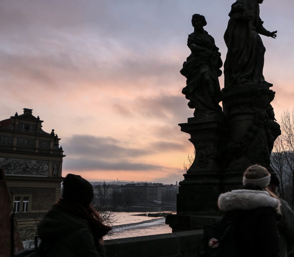 Charles Bridge in Prague at sunrise. Avoid the crowds in Prague by visiting as the sun rises!