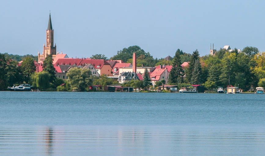 The sparkling lake and quaint church steeple visible from the Ravensbrück Concentration Camp