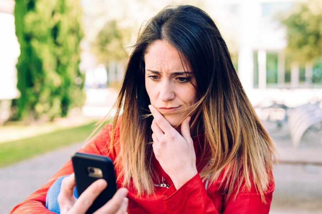 puzzled woman looks at phone